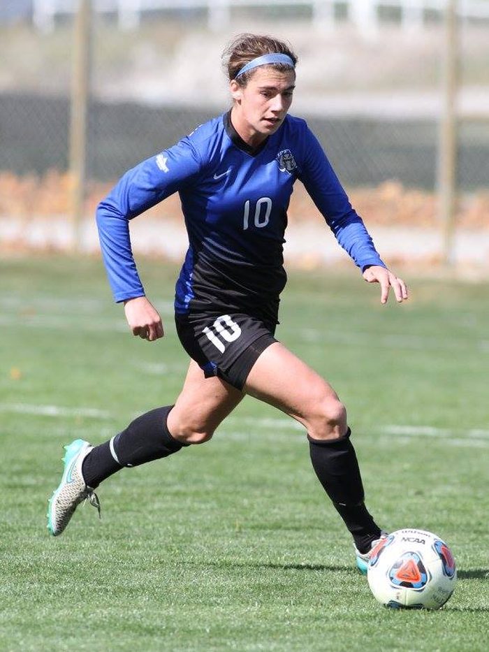 Kal Mogler driving forward with the ball during a collegiate soccer match